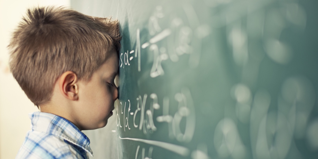 Little boy in math class overwhelmed by the math formula.